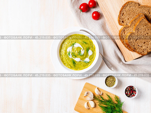 large white bowl with vegetable green cream soup of broccoli, zucchini, green peas. Стоковое фото, фотограф Natalia Gdovskaia / Фотобанк Лори