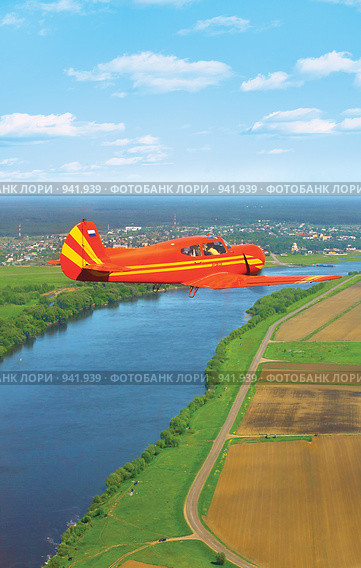 Легкий самолет Як-18Т в небе над рекой (2009 год). Редакционное фото, фотограф Евгения Водолазская / Фотобанк Лори