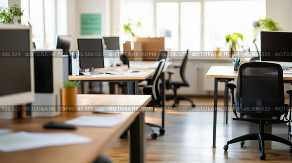 Light wood desks and black ergonomic chairs fill a bright, modern office. Стоковое AI-изображение, AI-художник Сергей Толмачёв / Фотобанк Лори