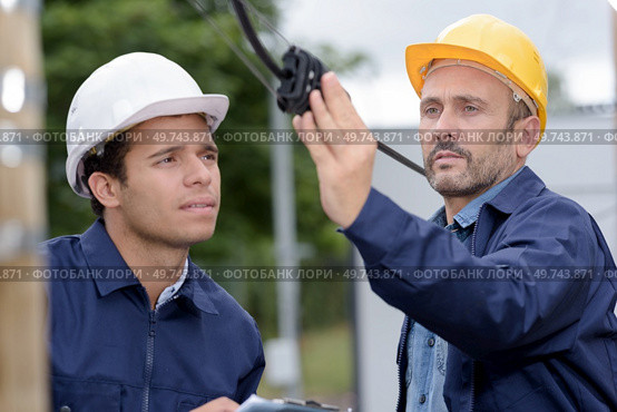 lineman checking an outdoor cable. Стоковое фото, агентство Ingram Publishing / Фотобанк Лори