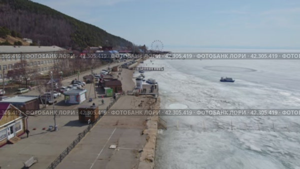 Listvyanka village, a popular tourist destination on the shores of Lake Baikal. Tourists walk on the spring ice, a hovercraft transports travelers. (2024 год). Стоковое видео, видеограф Виктория Тельминова / Фотобанк Лори