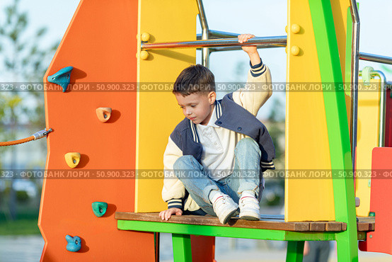 Little boy climbs in rope park or children playground at sunny day. Agility and climbing outdoor amusement center for children. Childhood and sport concept. High quality photo. Стоковое фото, фотограф Ирина Михайличенко / Фотобанк Лори