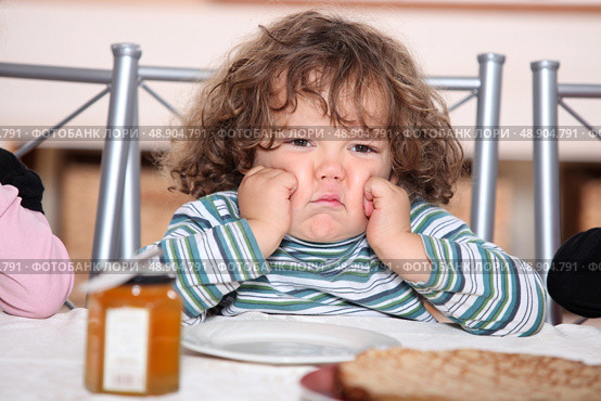 little boy grouching in front a plate of crepes. Стоковое фото, агентство Ingram Publishing / Фотобанк Лори