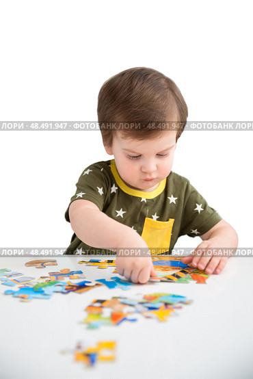 Little boy playing puzzle on a white background. Стоковое фото, фотограф Юлия Бабкина / Фотобанк Лори