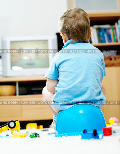 Little boy sitting at the chamber pot and watching television. Стоковое фото, агентство BE&W Photo / Фотобанк Лори