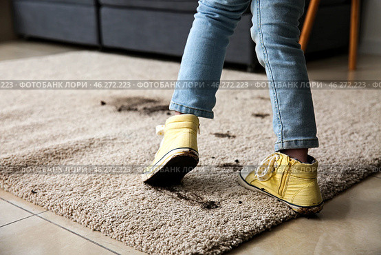 Little girl in muddy shoes messing up carpet at home. Стоковое фото, фотограф Pixel_shot / Фотобанк Лори