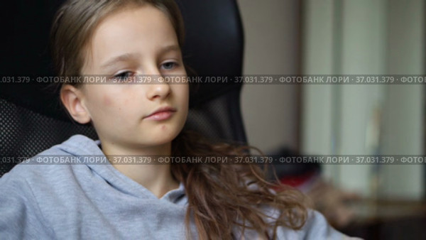 Little sad girl is sitting on black office chair, punishment, serious face. Стоковое видео, видеограф Ольга Балынская / Фотобанк Лори