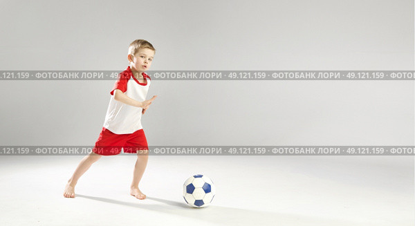 Little talented boy playing soccer. Стоковое фото, агентство Ingram Publishing / Фотобанк Лори