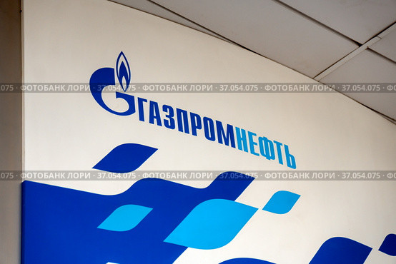 Логотип и название корпорации «Газпромнефть» на белом щите АЗС (2019 год). Редакционное фото, фотограф Светлана Попова / Фотобанк Лори