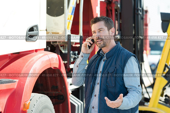lorry driver making questioning gesture while talking on telephone. Стоковое фото, агентство Ingram Publishing / Фотобанк Лори