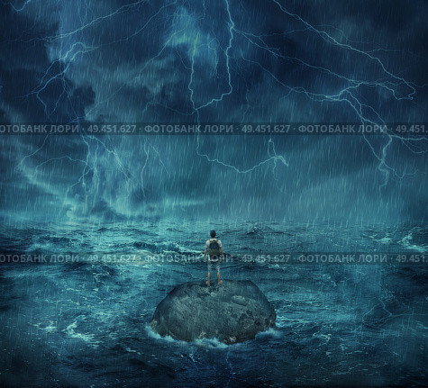 Lost man standing abandoned on a rock island in middle of the ocean, in a stormy night with lightnings in the sky. Looking for help, trying to survive. Adventure, journey and hard determination concept. Стоковое фото, агентство Ingram Publishing / Фотобанк Лори