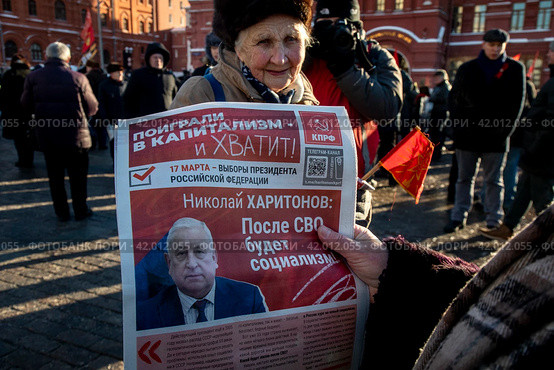 Люди читают агитационные материалы депутата Государственной Думы РФ от КПРФ Николая Харитонова на Манежной площади в центре города Москвы, Россия (2024 год). Редакционное фото, фотограф Николай Винокуров / Фотобанк Лори