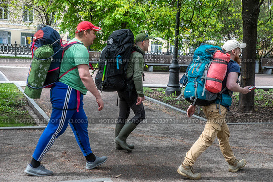 Люди идут с рюкзаками и палатками по Цветному бульвару в центре города Москвы, Россия (2024 год). Редакционное фото, фотограф Николай Винокуров / Фотобанк Лори
