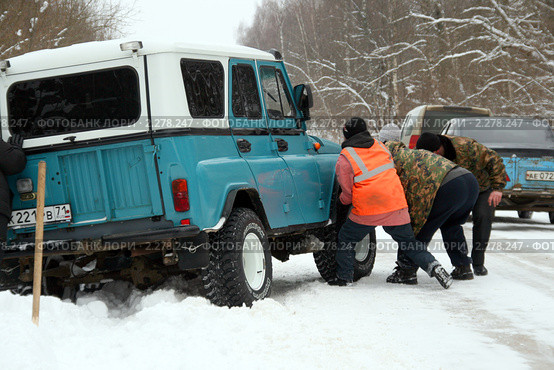 Люди вытаскивают застрявшую на обочине в сугробе машину (2011 год). Редакционное фото, фотограф Щеголева Ольга / Фотобанк Лори