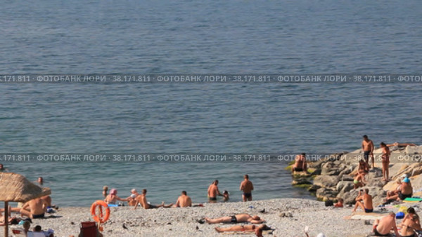 Люди загорают на каменистом пляже морского побережья (2018 год). Редакционное видео, видеограф Цыбин Вадим / Фотобанк Лори