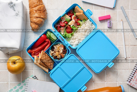 Lunchboxes with delicious food and different stationery on beige tile background. Стоковое фото, фотограф Pixel_shot / Фотобанк Лори
