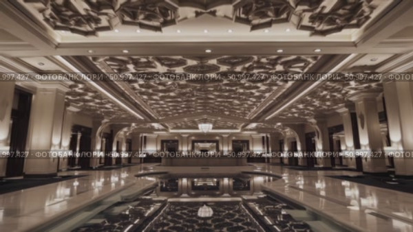 Luxurious hotel lobby with gleaming marble flooring, tranquil reflecting pool, and elaborate ceiling highlighting elegant, high end interior design elements. Стоковое AI-видео, аниматор Данил Руденко / Фотобанк Лори