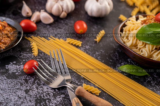 Macaroni sauteed with tomatoes and basil on a gray plate. Стоковое фото, агентство Ingram Publishing / Фотобанк Лори