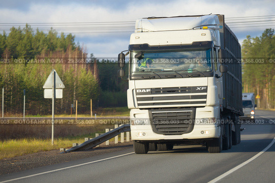 Магистральный тягач DAF XF105 с прицепом на трассе облачным днем (2018 год). Редакционное фото, фотограф Виктор Карасев / Фотобанк Лори