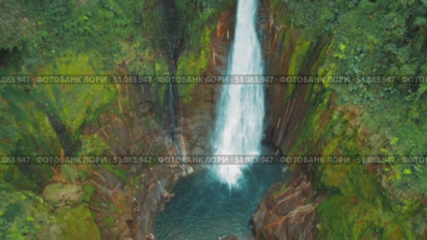 Magnificent waterfall plummeting into circular pool deep in Costa Rican jungle. Стоковое видео, видеограф Ольга Сухарева / Фотобанк Лори