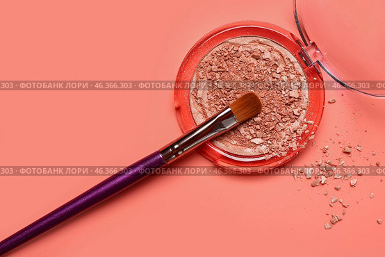 Makeup brush and broken highlighter on red background. Стоковое фото, фотограф Pixel_shot / Фотобанк Лори