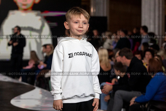 Мальчик демонстрирует одежду из коллекции российского бренда Lucky child на подиуме фестиваля детской моды KIDS FASHION WEEK в "Центральном детском магазине на Лубянке" (ЦДМ) в Москве, Россия (2023 год). Редакционное фото, фотограф Николай Винокуров / Фотобанк Лори