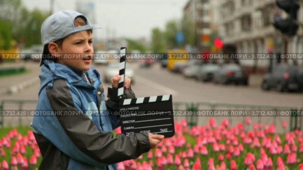 Мальчик держит в руках хлопушку. Стоковое видео, видеограф Losevsky Pavel / Фотобанк Лори
