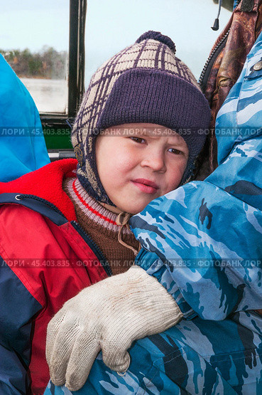 Мальчик в лодке. Его отец за рулем, и они по реке едут домой. Их родовое имение находится в лесу ( недалеко от реки ). Они, коренные жители народов севера - ханты, здесь живут годами. Основные продукты - самые, что ни на есть натуральные. Все остальное покупают раз в месяц, в городе. Сообщение с городом круглый год по реке , километров 20-25... (2011 год). Редакционное фото, фотограф Павел Просянов / Фотобанк Лори