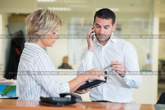 male assistant executing managers orders. Стоковое фото, агентство Ingram Publishing / Фотобанк Лори