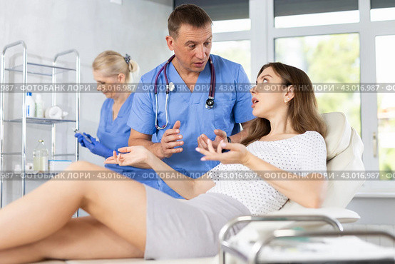 Male beautician, together with a nurse, examines face of an young woman and plans facelift procedures. Стоковое фото, фотограф Яков Филимонов / Фотобанк Лори