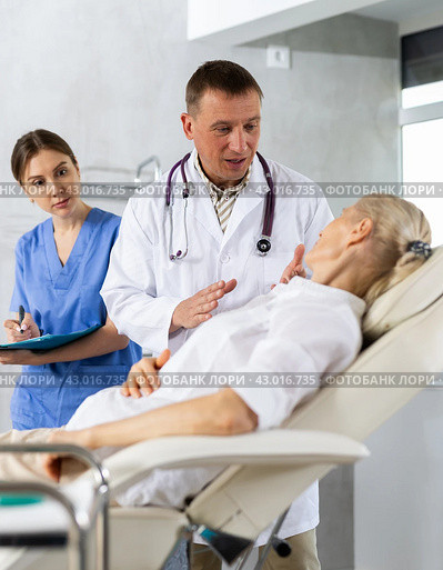 Male beautician, together with a nurse, examines the face of an mature woman and plans facelift procedures. Стоковое фото, фотограф Яков Филимонов / Фотобанк Лори