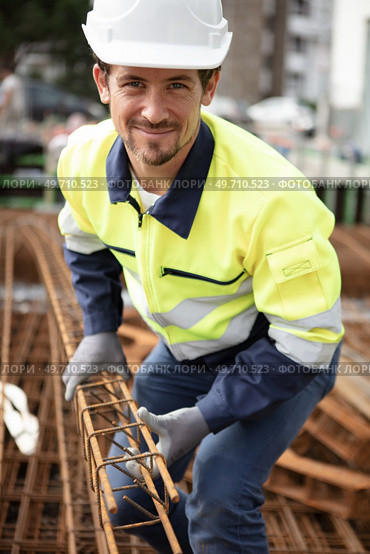 male builder moving reinforcement bars. Стоковое фото, агентство Ingram Publishing / Фотобанк Лори