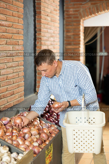Male customer made beeline for fresh produce section, pick up onion for morning salad. Стоковое фото, фотограф Яков Филимонов / Фотобанк Лори