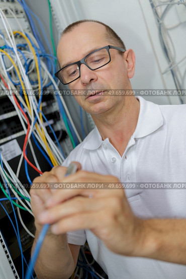 male electrician working on fusebox. Стоковое фото, агентство Ingram Publishing / Фотобанк Лори