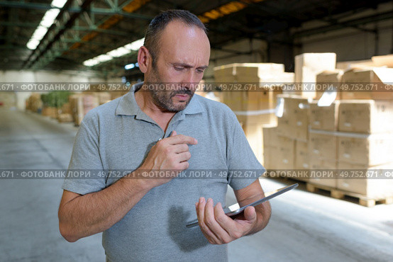 male looking at clipboard in warehouse. Стоковое фото, агентство Ingram Publishing / Фотобанк Лори