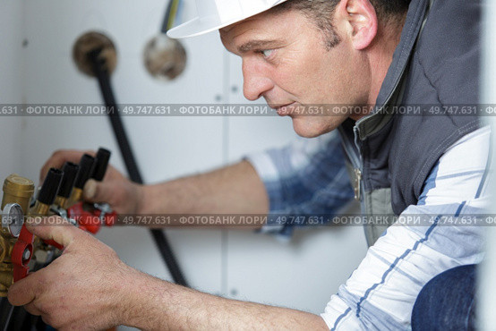 male plumber reading the water meter. Стоковое фото, агентство Ingram Publishing / Фотобанк Лори