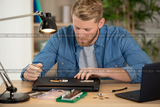 male student during repair of his laptop. Стоковое фото, агентство Ingram Publishing / Фотобанк Лори