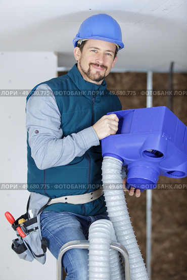 male technician repairing industrial air conditioner indoors. Стоковое фото, агентство Ingram Publishing / Фотобанк Лори