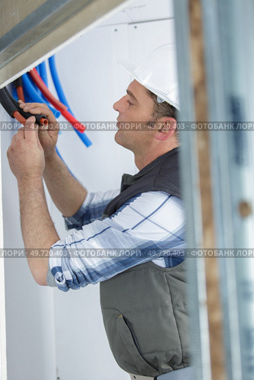 male technician repairing pipes indoors. Стоковое фото, агентство Ingram Publishing / Фотобанк Лори