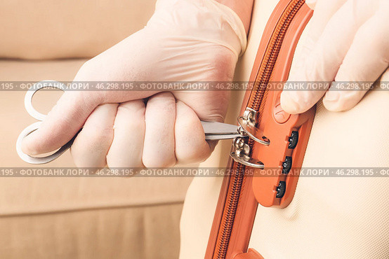 Male thief trying to open stolen suitcase, closeup. Стоковое фото, фотограф Pixel_shot / Фотобанк Лори