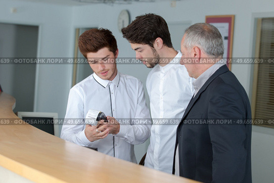male trainee receptionists in receptionist class. Стоковое фото, агентство Ingram Publishing / Фотобанк Лори