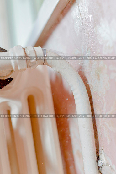 male worker is fixing a leaky radiator. Стоковое фото, агентство Ingram Publishing / Фотобанк Лори