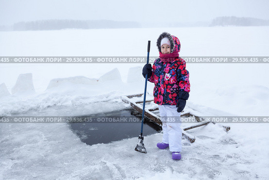 Маленькая девочка с ледорубом стоит у проруби на озере. Стоковое фото, фотограф Кекяляйнен Андрей / Фотобанк Лори