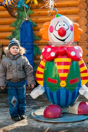 Маленький мальчик стоит рядом с большим надувным клоуном (2014 год). Редакционное фото, фотограф Игорь Низов / Фотобанк Лори