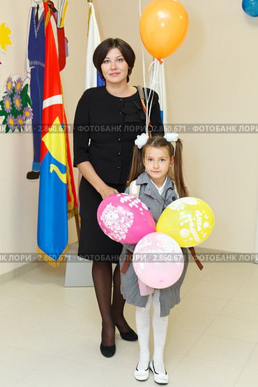 Мама и дочь первоклассник возле знамен в школе (2011 год). Редакционное фото, фотограф Кекяляйнен Андрей / Фотобанк Лори