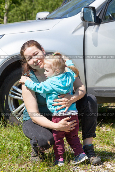 Мама обнимает и успокаивает дочку возле автомобиля. Стоковое фото, фотограф Кекяляйнен Андрей / Фотобанк Лори