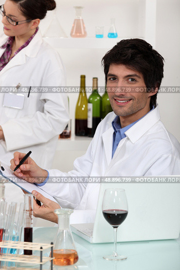 Man and woman conducting experiment on wine. Стоковое фото, агентство Ingram Publishing / Фотобанк Лори