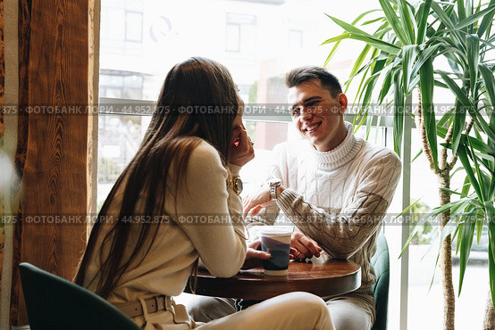 Man and Woman Sitting at Table Talking. Стоковое фото, фотограф Сергей Толмачёв / Фотобанк Лори
