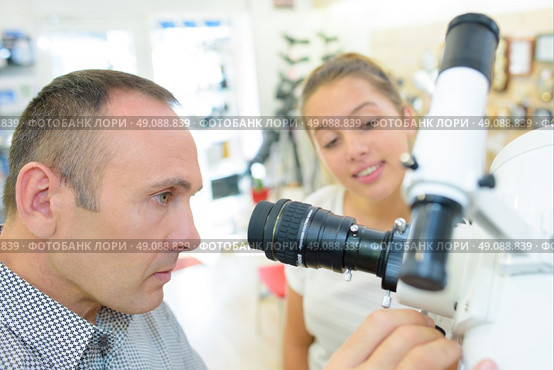 Man and young lady looking at telescope. Стоковое фото, агентство Ingram Publishing / Фотобанк Лори