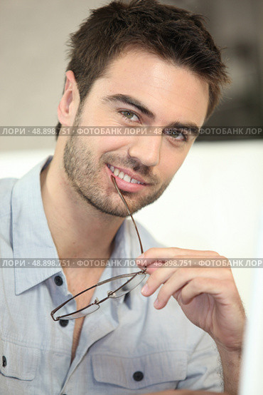 Man biting his glasses. Стоковое фото, агентство Ingram Publishing / Фотобанк Лори